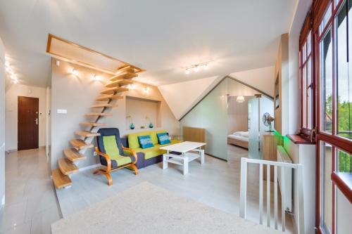 a room with a spiral staircase and a living room at Willa Hania, Sun & Snow in Krynica Morska