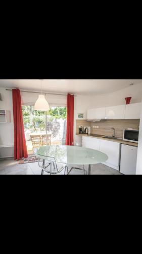 - une cuisine avec une table en verre dans une pièce dans l'établissement MICRO MAISON ROYAN CENTRE VILLE/PLAGE A PIED, à Royan