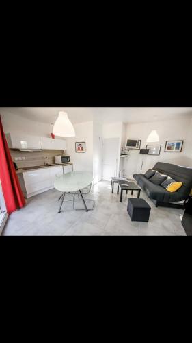 a living room with a couch and a table at MICRO MAISON ROYAN CENTRE VILLE/PLAGE A PIED in Royan