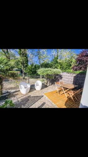 two toilets sitting next to a table and a bench at MICRO MAISON ROYAN CENTRE VILLE/PLAGE A PIED in Royan