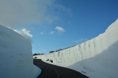 a road covered in snow next to a wall at Hardanger Fjordtun PANORAMA cabin near the Hardangerfjord with fantastic fjordview, silence and nature in Herand