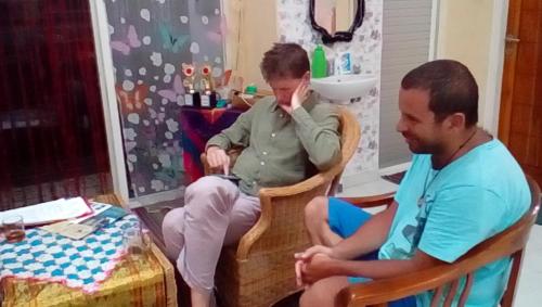 two men sitting in chairs in a room at D-Rima Homestay Ruteng in Ruteng