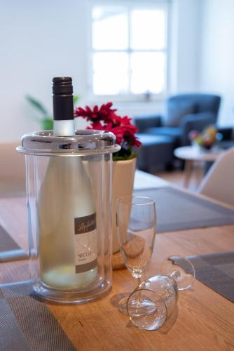 a bottle and two wine glasses on a table at Ferienwohnungen Windischeschenbach by HausGruenerBaum in Windischeschenbach