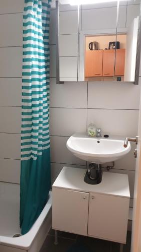 a bathroom with a sink and a shower curtain at Workers-Sleep-Station in Cologne