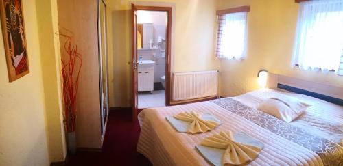 a bedroom with a bed with two towels on it at Pension Erika in Františkovy Lázně