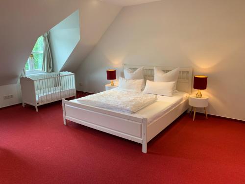 ein Schlafzimmer mit einem großen weißen Bett mit zwei Lampen in der Unterkunft Familien-Suite in Villa in Hildesheim