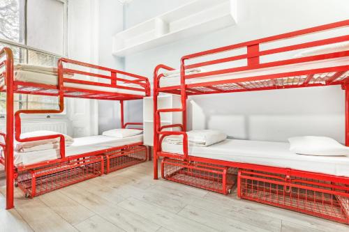 a room with three bunk beds in a building at Astor Victoria Hostel in London