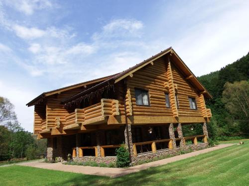 a log cabin in the middle of a field at Casa din Vale in Săcuieu