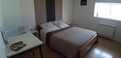 a small bedroom with a bed and a table at L'Escapade63 in Riom