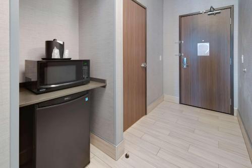 a hotel room with a microwave and a door at Comfort Suites Kennewick at Southridge in Kennewick