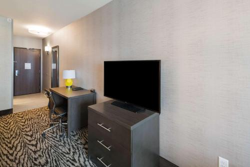a room with a television on a dresser with a desk at Comfort Suites Kennewick at Southridge in Kennewick