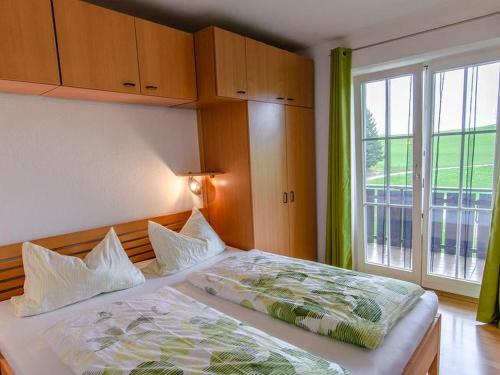 1 dormitorio con cama y ventana grande en Heizmannshof, en Hofstetten