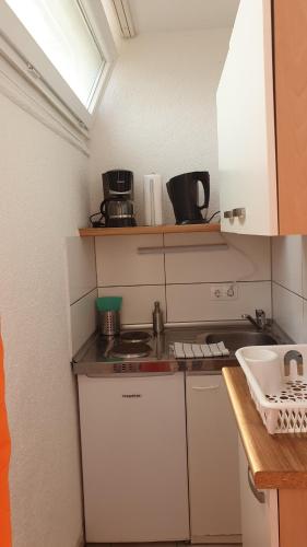 a small kitchen with a stove and a sink at Workers-Sleep-Station in Cologne