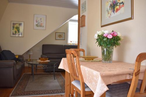 a living room with a table with a vase of flowers at Ferienwohnungen und Gästezimmer Peter Busch in Bernkastel-Kues