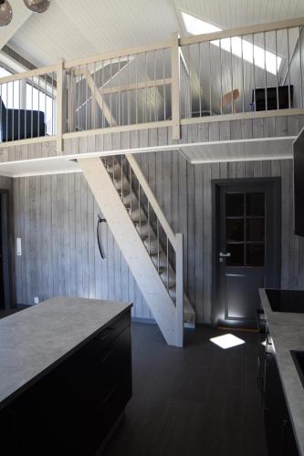 a staircase in a room with a living room at Lofoten Cabins - Kåkern in Ramberg