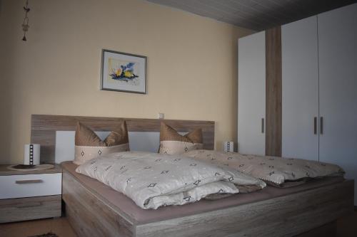 a bedroom with a large bed with a wooden headboard at Ferienwohnungen und Gästezimmer Peter Busch in Bernkastel-Kues