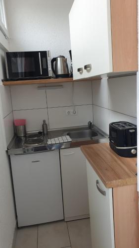 a small kitchen with a sink and a microwave at Workers-Sleep-Station in Cologne