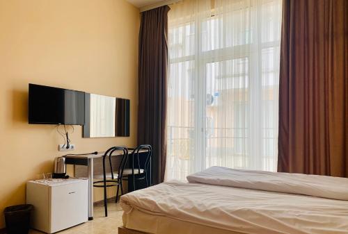 a bedroom with a bed and a tv and a window at Agora Studios in Plovdiv