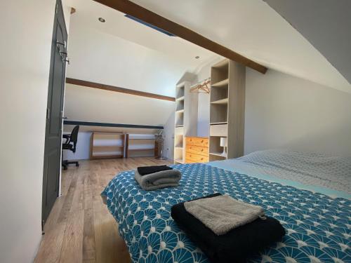 a bedroom with a bed with two towels on it at La Maison d'Arsène in Le Mans