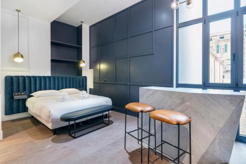 une chambre d'hôtel avec un lit et deux tabourets dans l'établissement RESIDENCE MONTEFIORE, à Cannes
