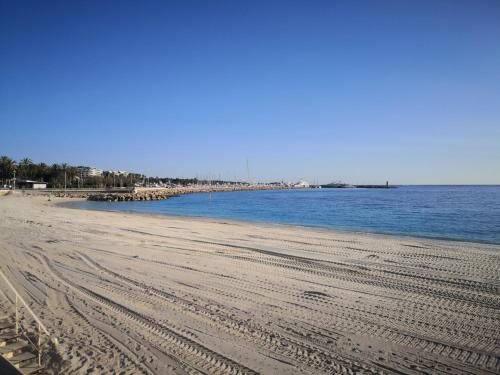 einen Strand mit Gleisen im Sand und Wasser in der Unterkunft APPARTEMENT CANNES MONTFLEURY in Cannes