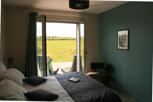 ein Schlafzimmer mit einem Bett und einem großen Fenster in der Unterkunft Le Clos Pen Kear in Plouarzel