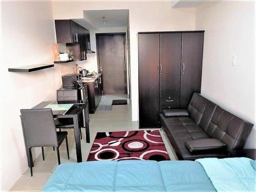 a living room with a couch and a kitchen at Studio Condominium - Short and Long Term Staycation in Manila