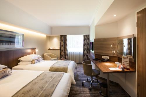 um quarto de hotel com duas camas e uma secretária em City Lodge Hotel Pinelands em Cidade do Cabo