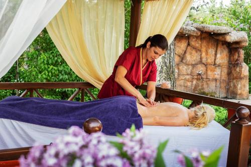 a woman is giving a woman a massage at Spa Hotel Dvoretsa in Velingrad