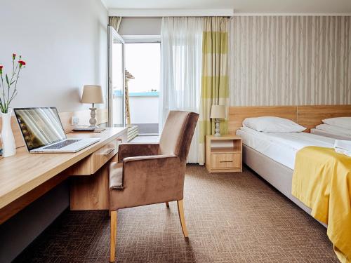 文克尼察的住宿－穆扎可凱酒店，酒店的客房配有一张带笔记本电脑的书桌