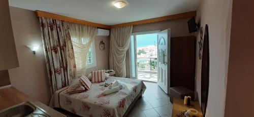 niewielka sypialnia z łóżkiem i oknem w obiekcie Athanasia Rooms w mieście Mariaí