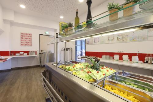 a kitchen with a counter filled with lots of food at Jugendherberge Bad Malente in Malente