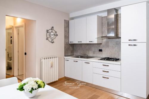 uma cozinha branca com armários brancos e uma mesa em Feel at Home - NEL CUORE DI LOVERE em Lovere