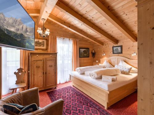 サンクト・ジョアン・イン・チロルにあるChalets Berglehenの木造家屋内のベッドルーム1室(大型ベッド1台付)