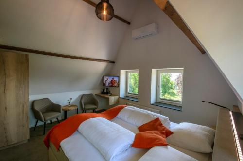 een slaapkamer met een wit bed en 2 ramen bij Hotel Bergrust in Bemelen