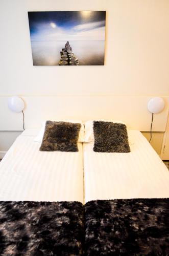 a bedroom with a bed with two pillows on it at Family Hotel Kooyk in Amsterdam