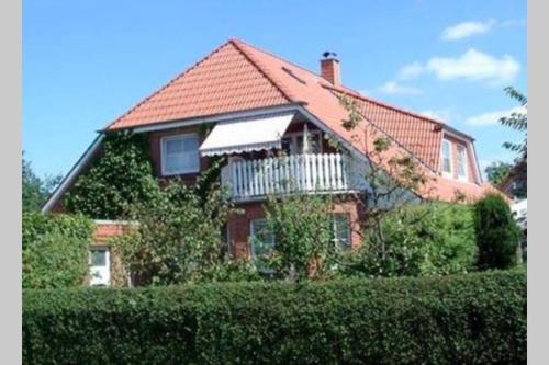 a large brick house with a porch and a balcony at Ferienwohnung Gisela Rohde in Bad Bramstedt
