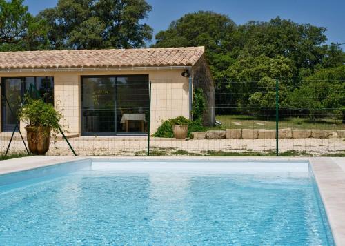 a swimming pool in front of a house at Le Mas du Berger in Saint-Quentin-la-Poterie