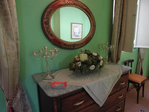 a dressing table with a mirror and flowers on it at Les Chandelles in San Menaio