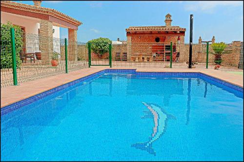 a large blue swimming pool in front of a house at Chalet Puente de Tabla in Conil de la Frontera