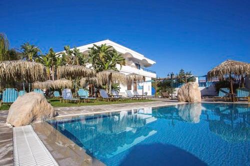 een zwembad met stoelen en parasols en een gebouw bij Aquarius Beach Hotel in Faliraki
