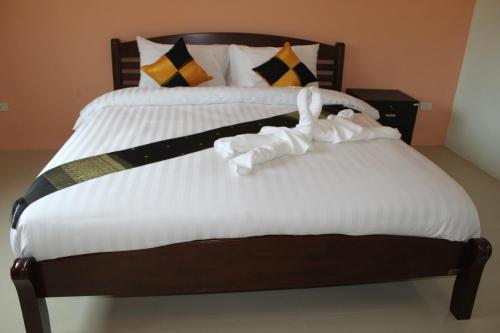 a bed with white sheets and swans on it at Maehaad Guesthouse in Mae Haad