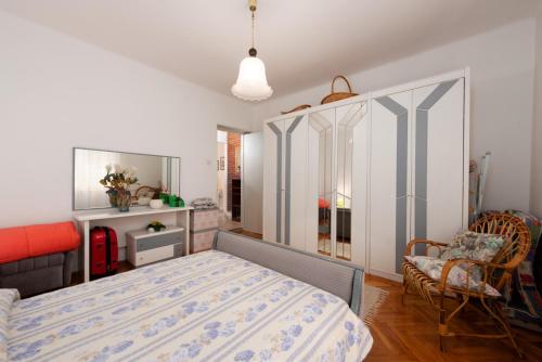 a bedroom with a bed and a chair at Apartment Nigra in Lovran