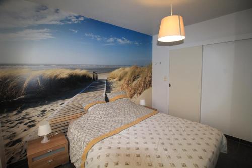 1 dormitorio con 1 cama y una pintura de playa en Bella Vista Walbo, en Blankenberge