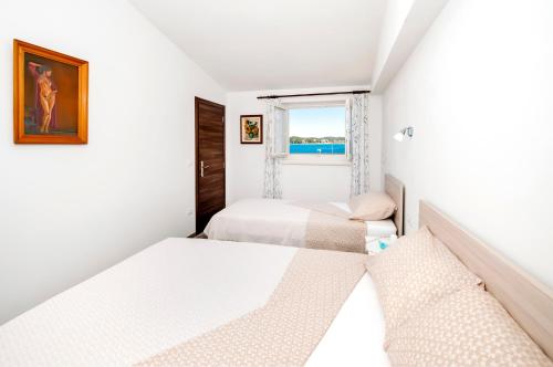2 Betten in einem kleinen Zimmer mit Fenster in der Unterkunft Casa Campus in Rovinj