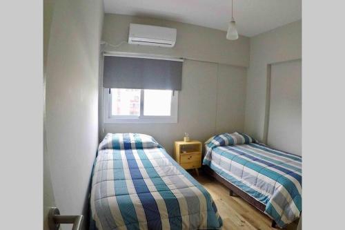 1 dormitorio con 2 camas y ventana en Depto Val en Mendoza