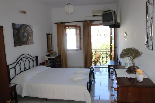 a bedroom with a bed and a television and a table at Michalis Studios in Lipsoi