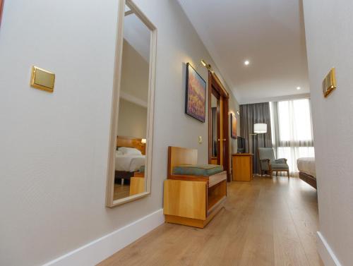 a hotel room with a bed and a mirror at Oca Puerta del Camino Hotel in Santiago de Compostela