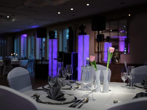a table with wine glasses and pink roses on it at Hotel Restaurant Clemens-August in Ascheberg