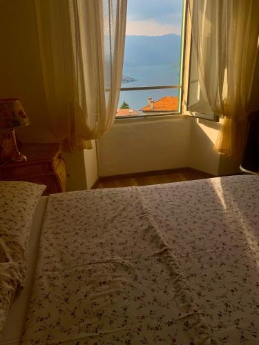 a bedroom with a bed and a window with a view at Holiday Home Liliana in Faggeto Lario 
